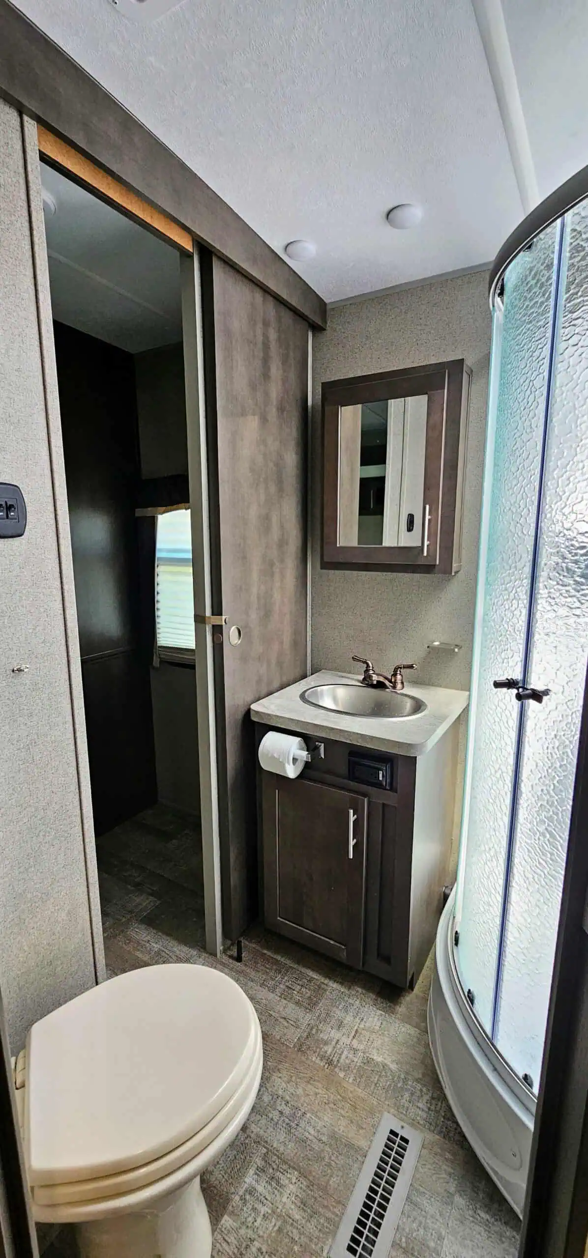 Compact RV bathroom with shower and sink.