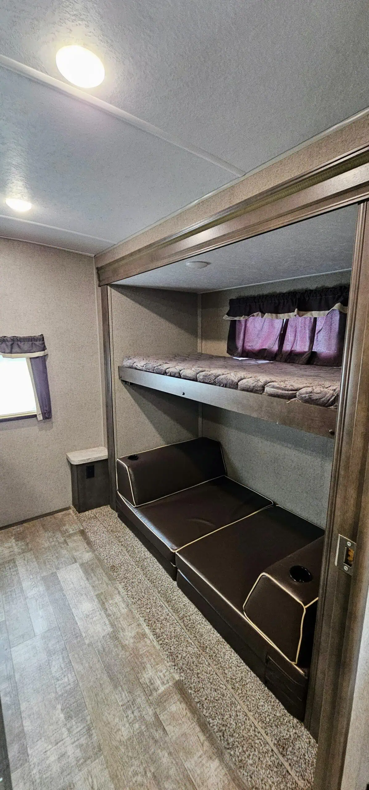 RV interior with bunk beds and seating area.