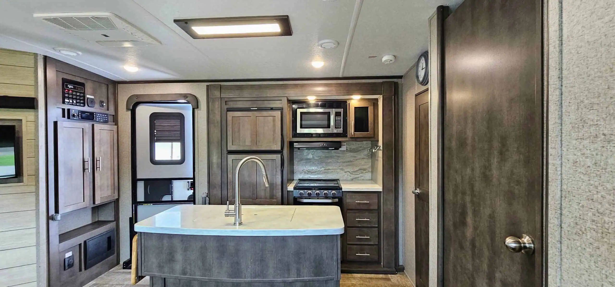 Modern RV kitchen with microwave and stove.