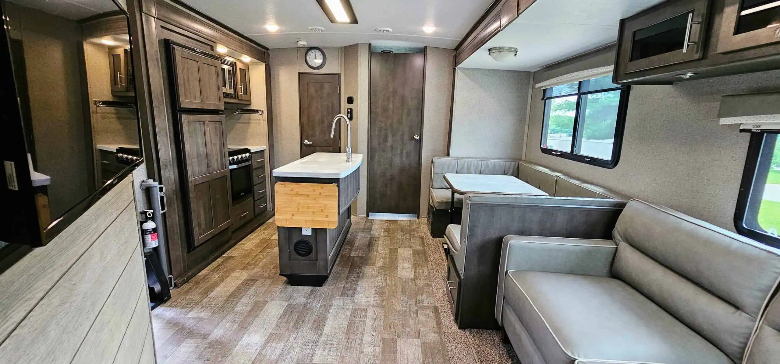 Modern RV interior with kitchen and seating.