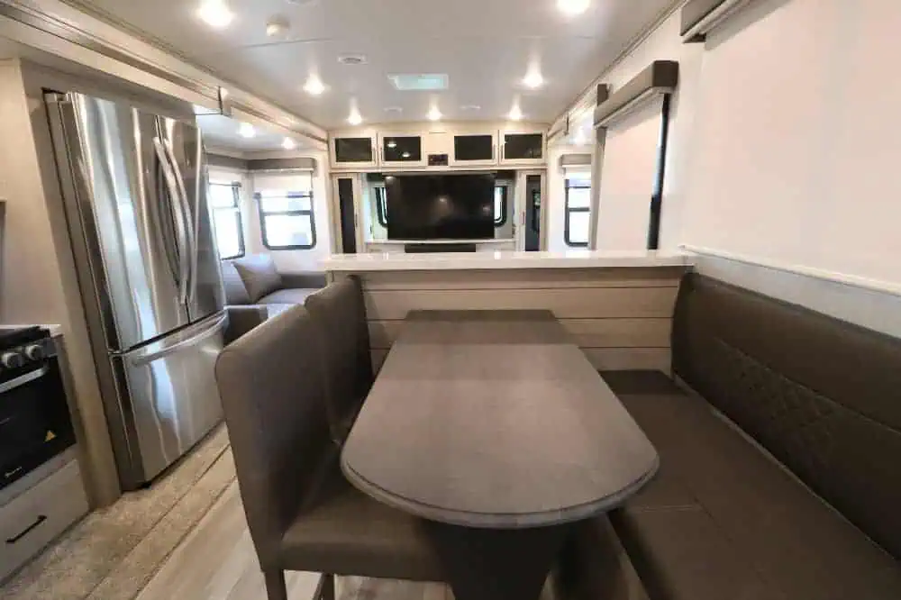 Modern RV interior with kitchen and dining area.