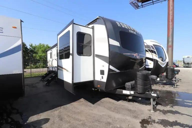 Parked travel trailers on display under blue sky.