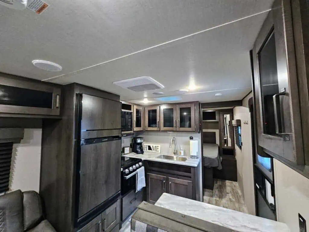 Modern RV kitchen interior with appliances and cabinets.