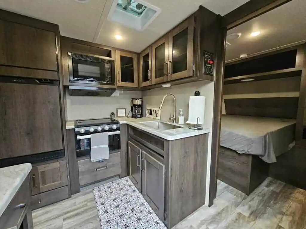 RV kitchen with bed in background