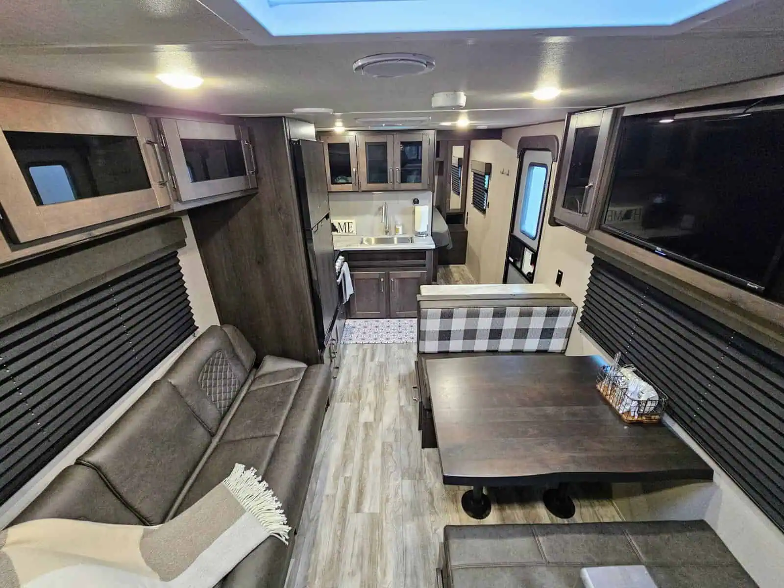 Interior of modern RV with kitchen and seating.