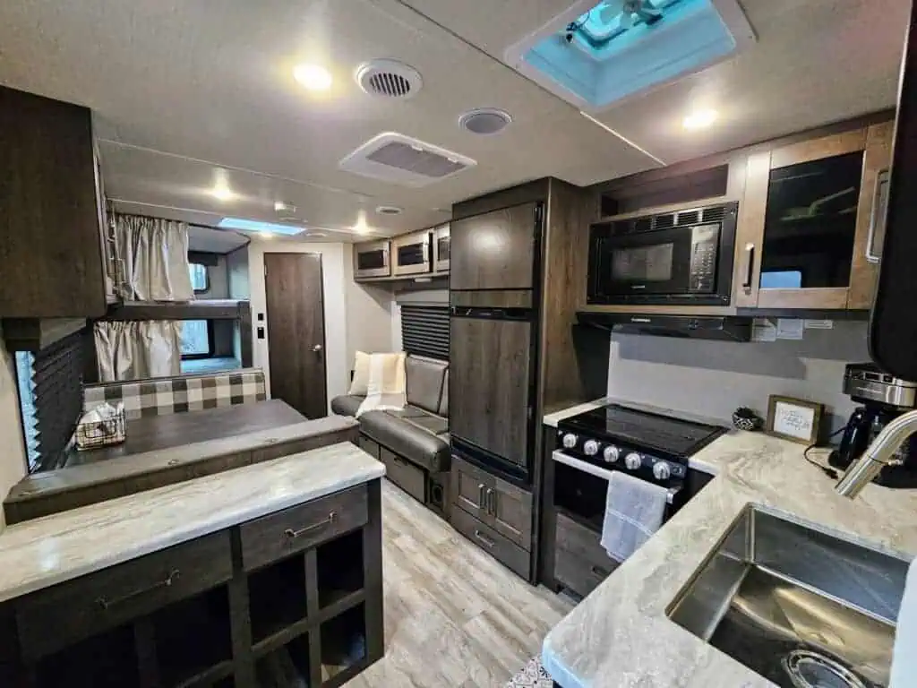 Cozy RV interior with kitchen and seating area.