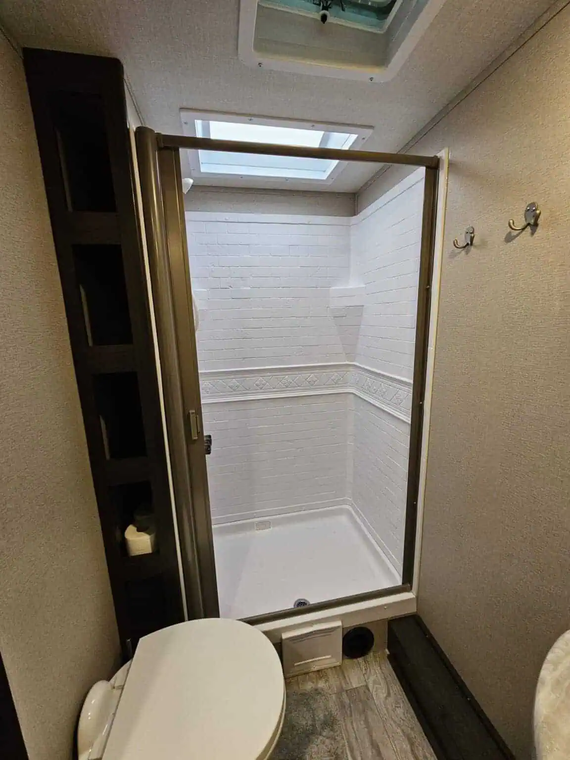 Modern RV bathroom with shower and skylight.