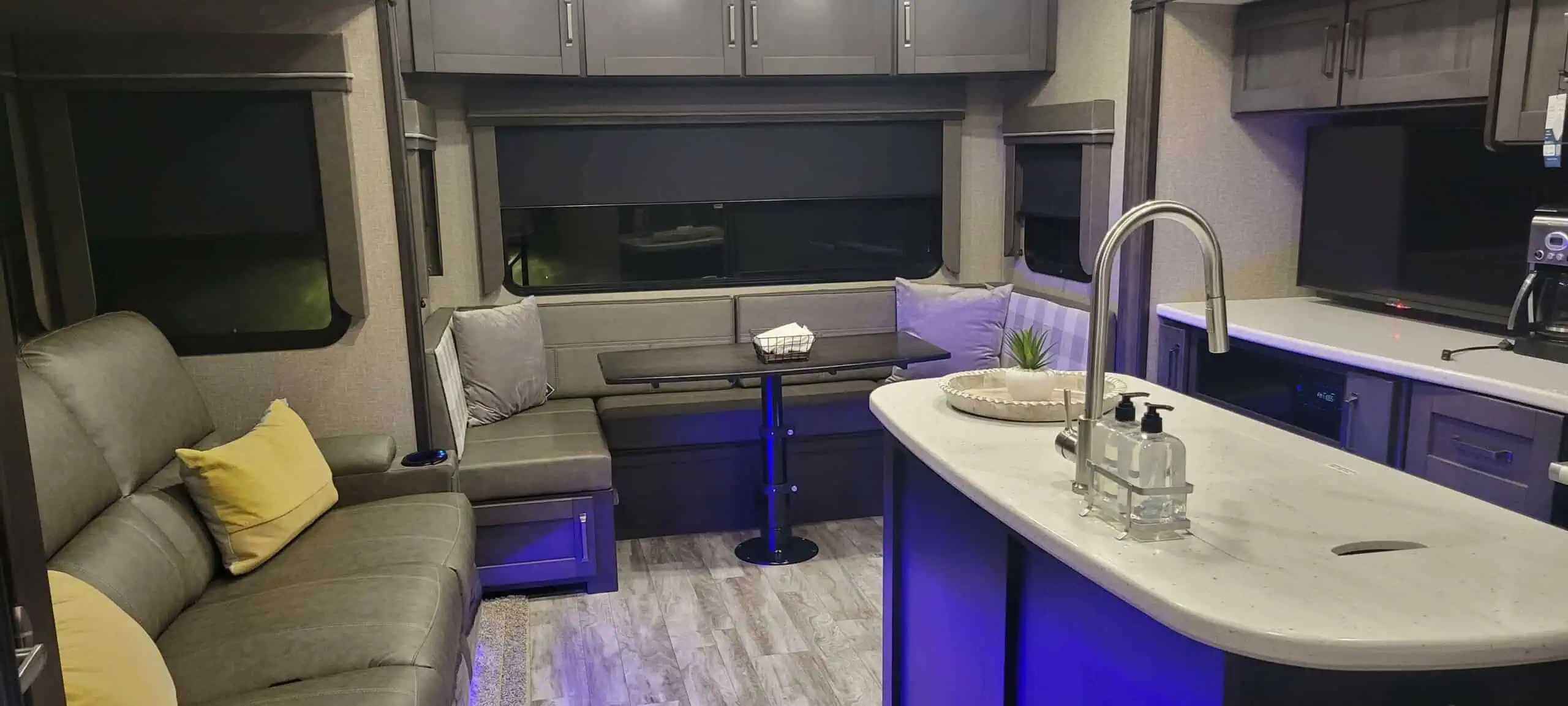 Modern RV interior with seating and kitchen island.