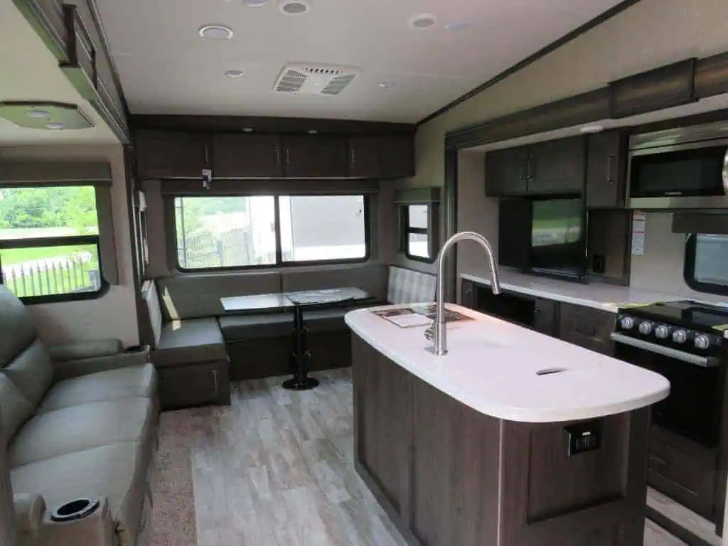 Modern RV interior with kitchen and seating area.