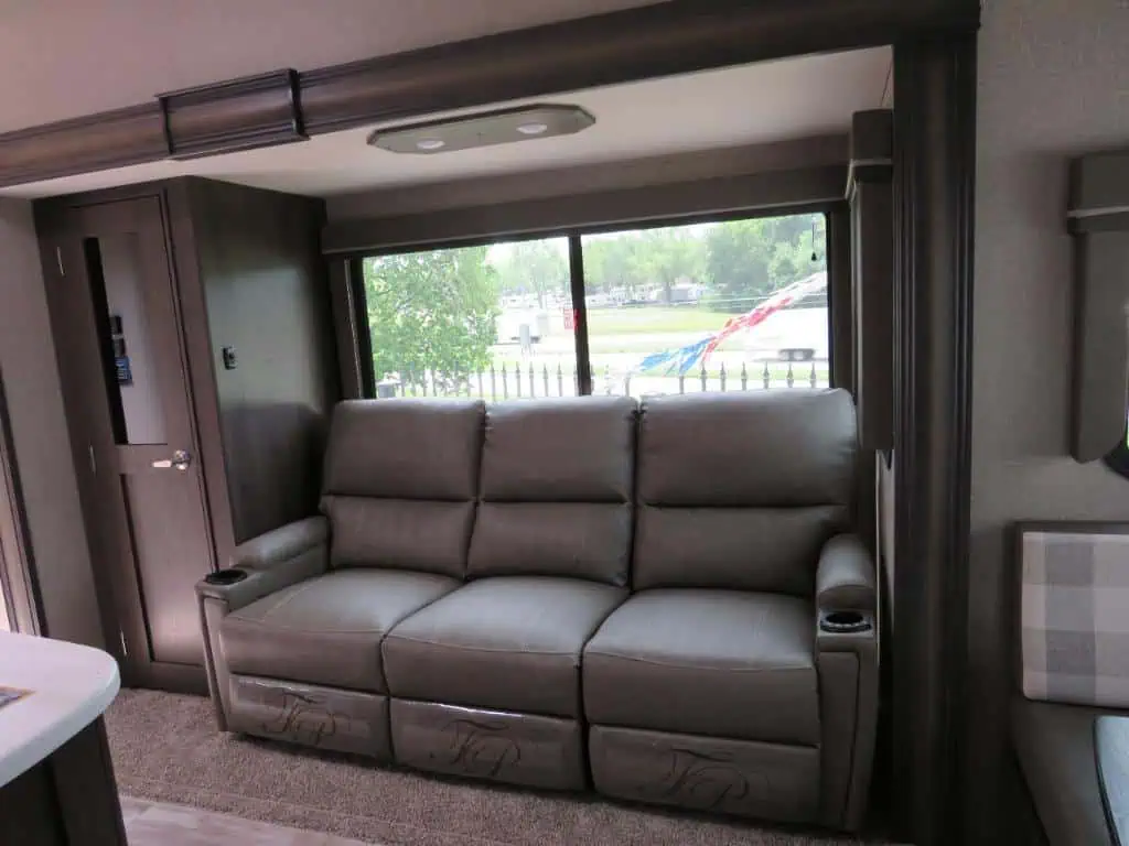 Modern RV interior with gray sofa and window.