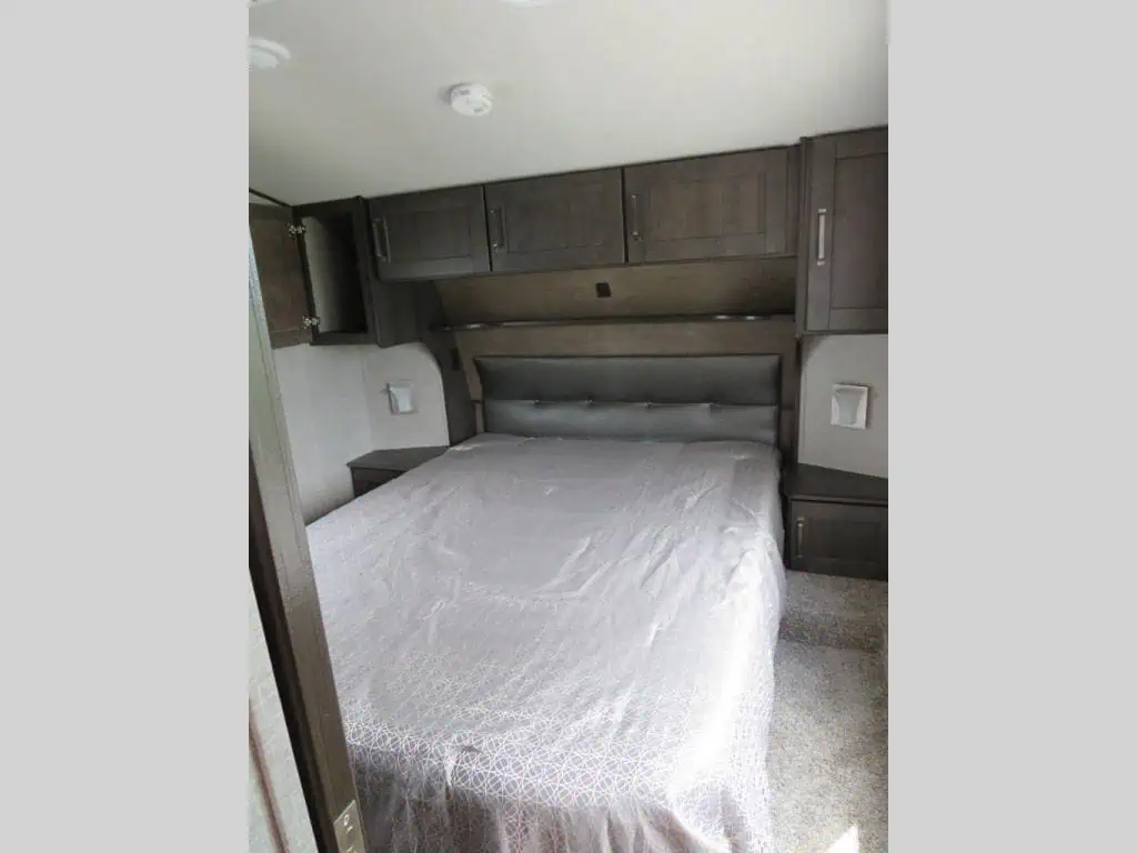 RV bedroom with queen size bed and cabinets